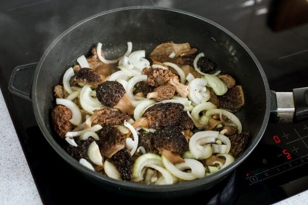 cast iron skillet with fried morels and ramps